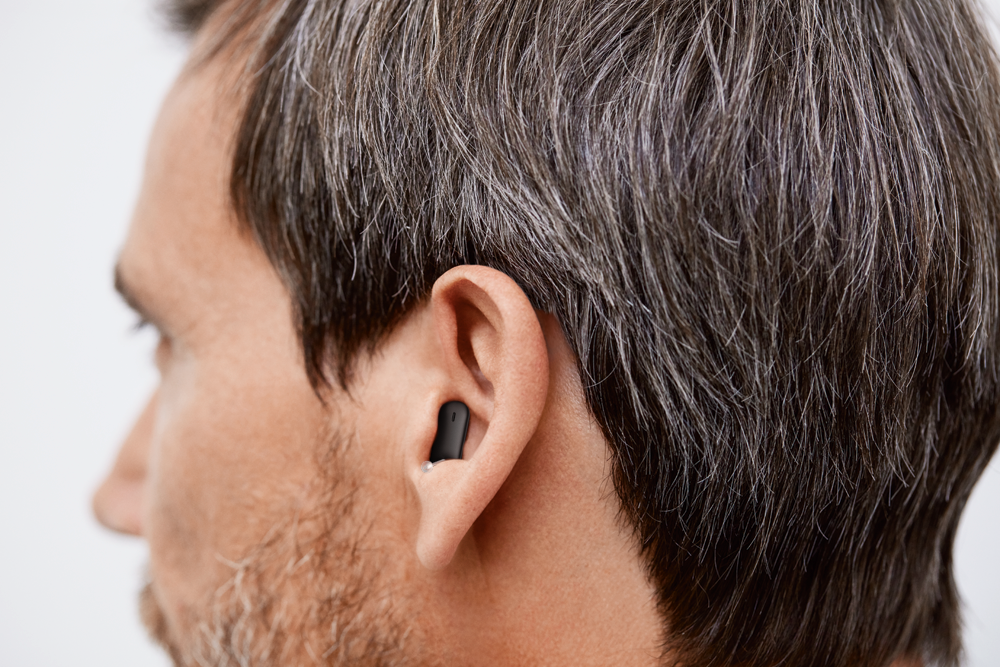 Young women, with a ReSound hearing aid. ReSound Vivia, a small BTE hearing aid.